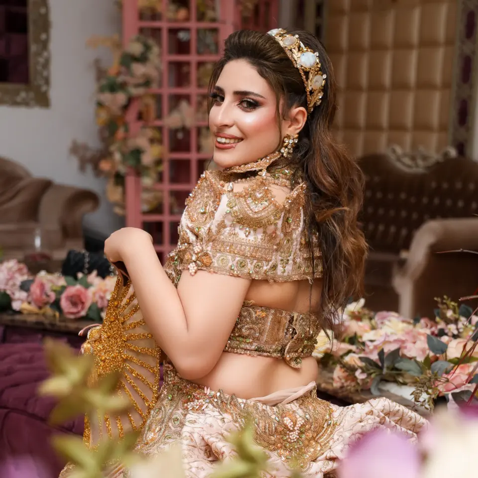 Femme en robe traditionnelle dorée assise dans un décor fleuri